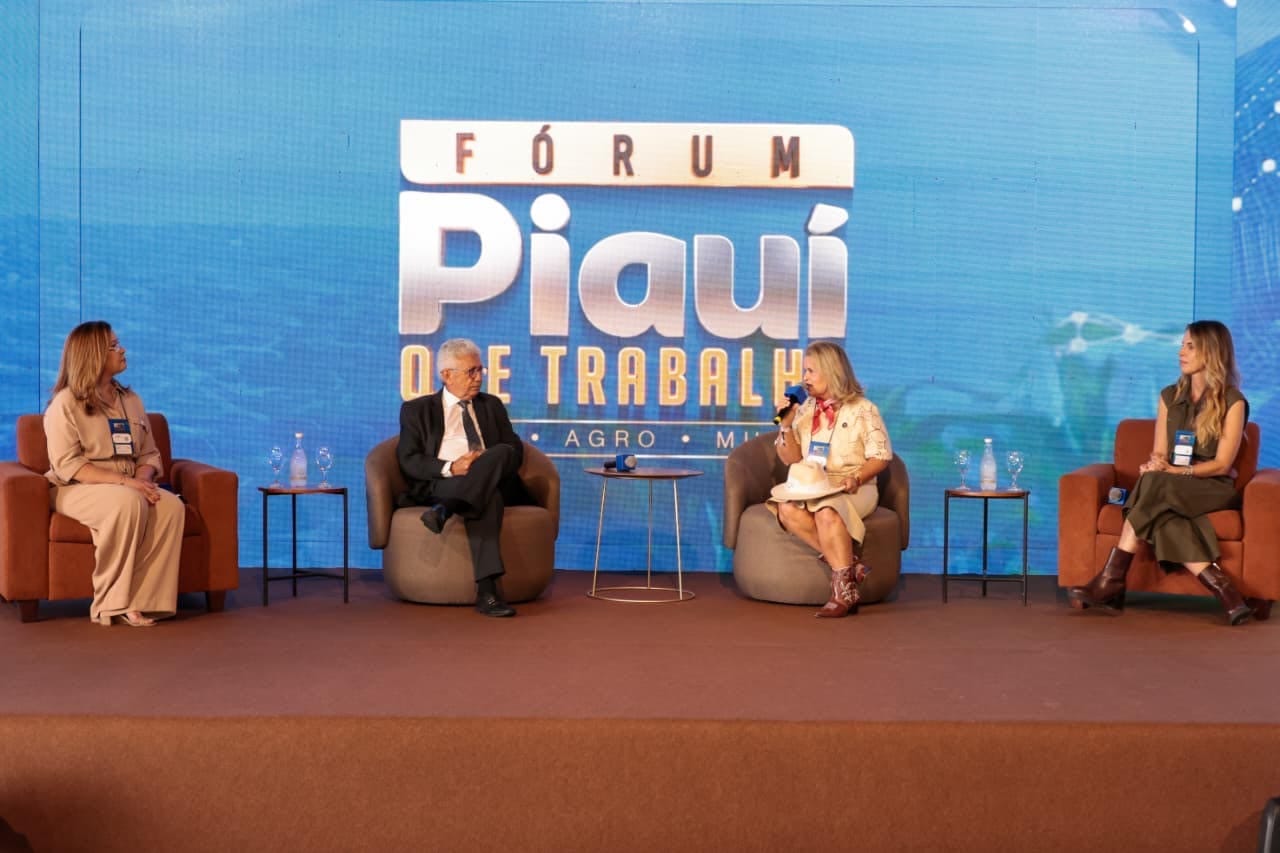 Painel "Transformar para desenvolver", com quatro participantes sentados no palco.
