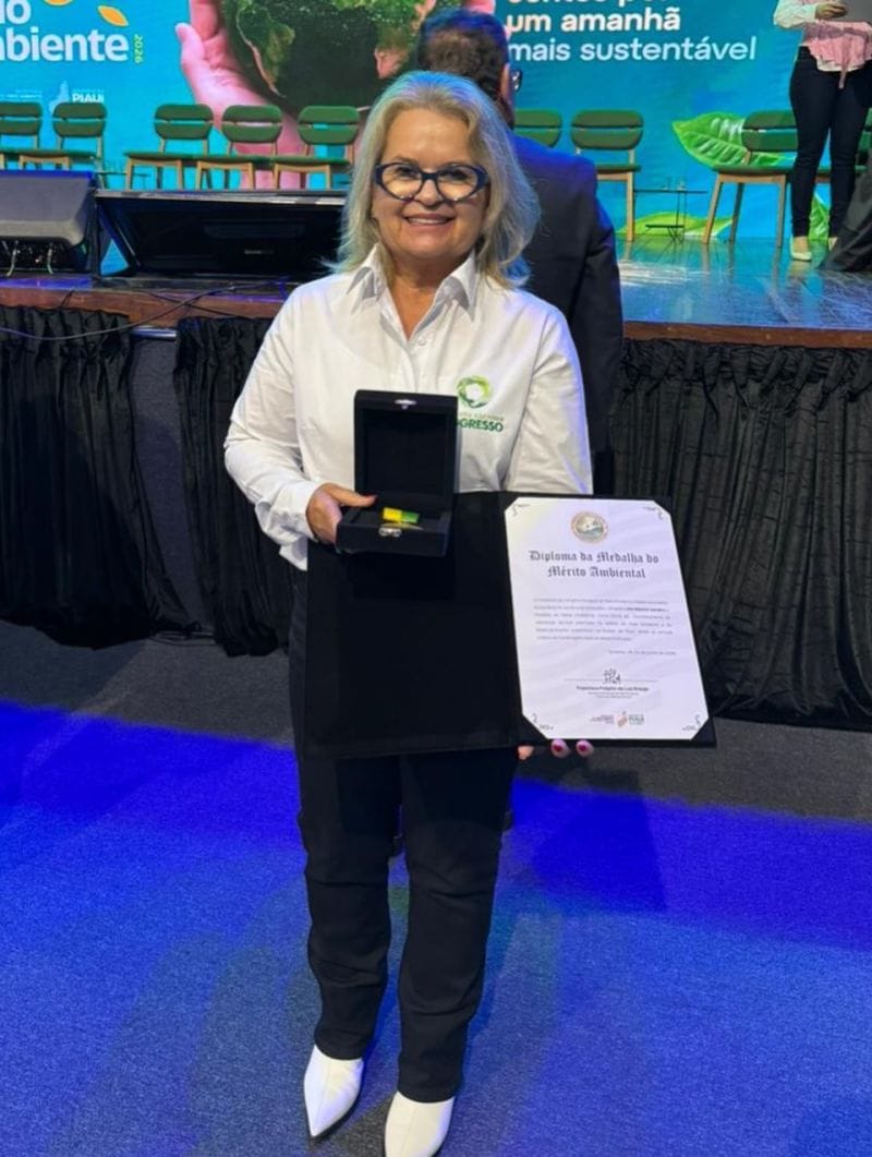 Ani Sanders segura o estojo com a medalha e o Diploma da Medalha do Mérito Ambiental.